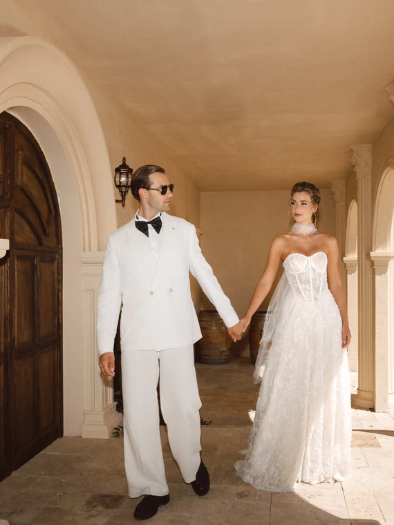 Kemerli villa koridorunda el ele yürüyen gelin ve damat