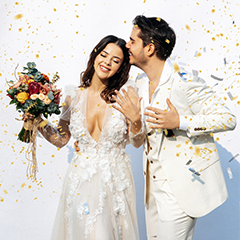 Konfeti altında buketli gelin ve beyaz ceketli damat